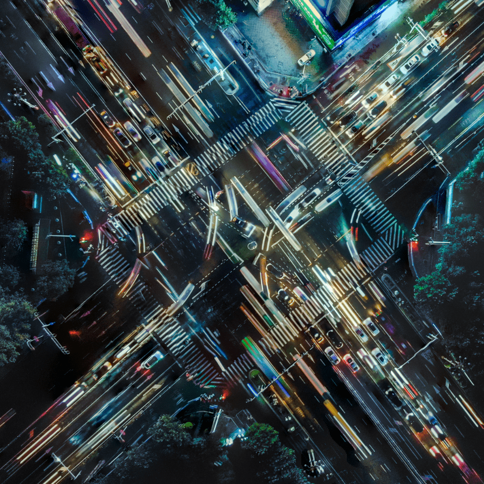 Arial view of a busy intersection at night with cars racing by