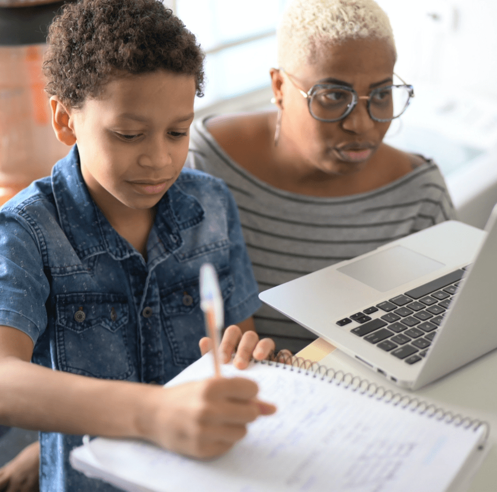 Teacher and young student working at a computer