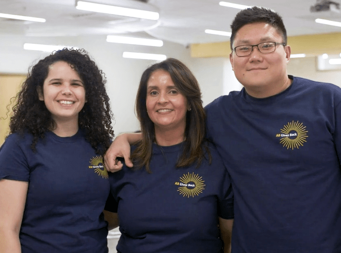 Three AB employees smiling at a volunteer event