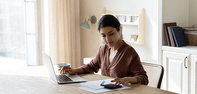Woman sitting at a home desk doing her taxes