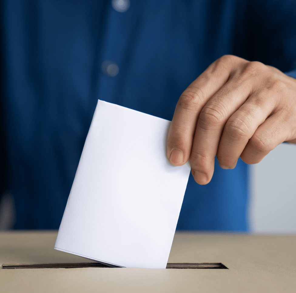 Hand dropping ballot into a box