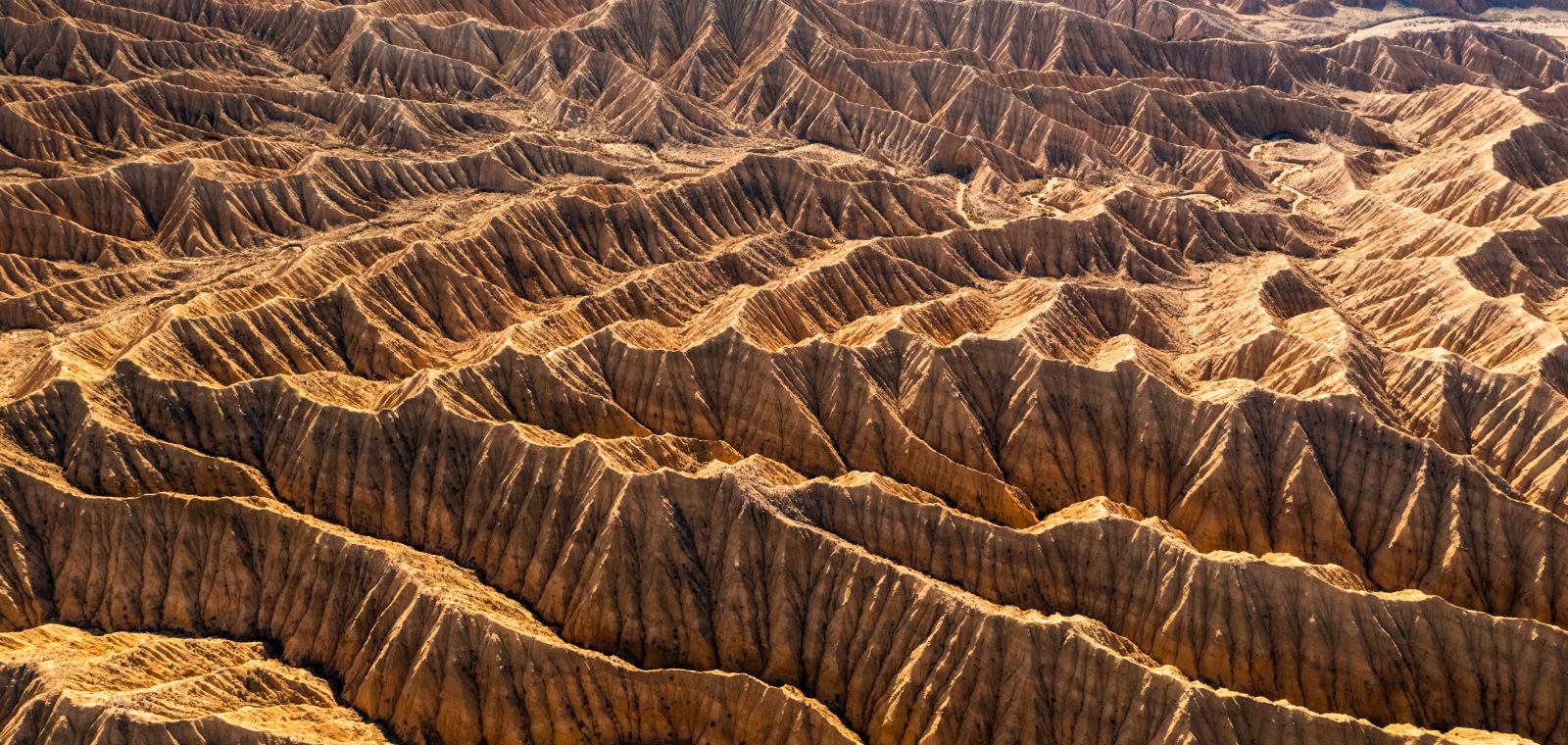 A jagged, rocky landscape unfolds under an aerial view 